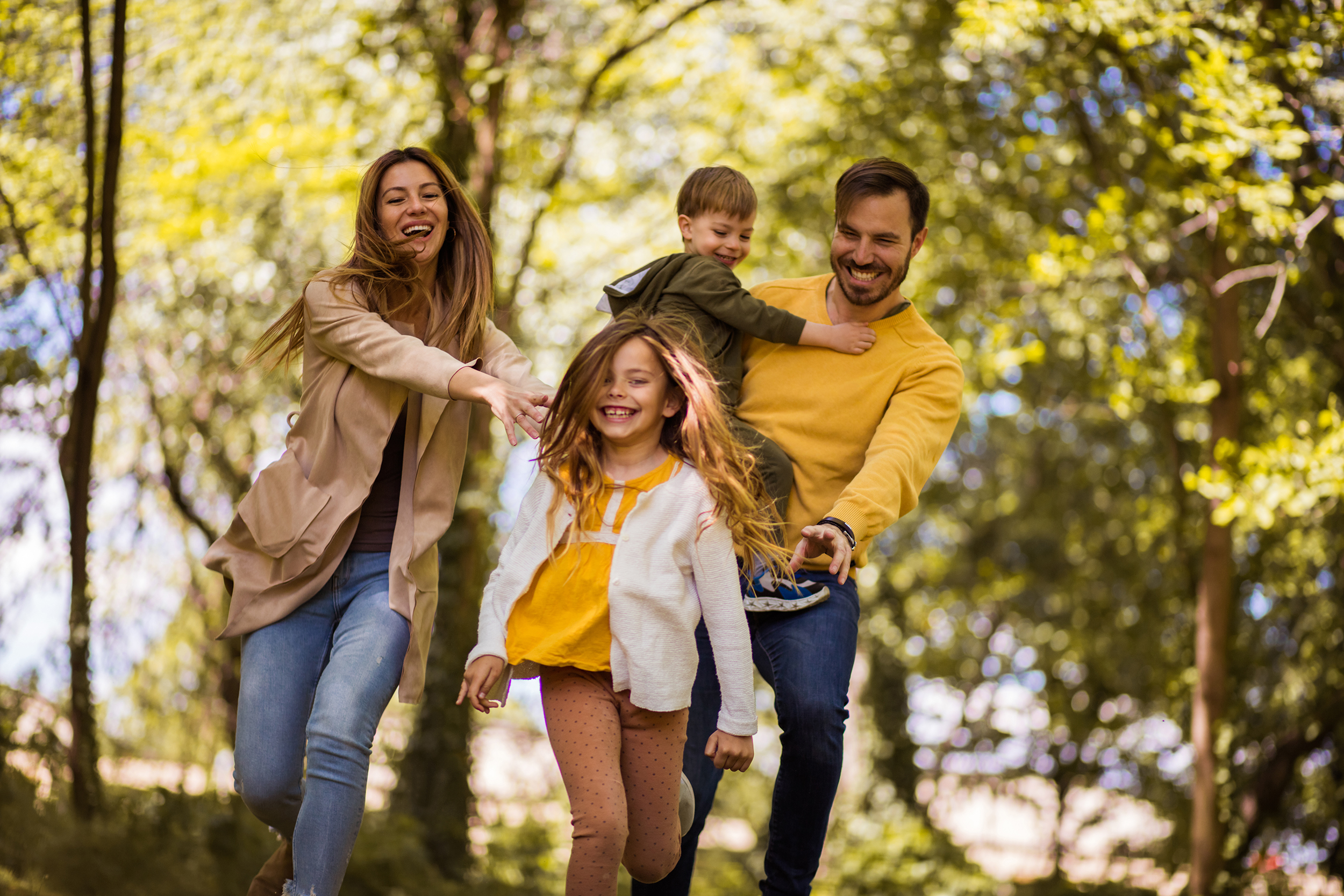 Happy family. Parents spending time with their children outside. Focus is on foreground.