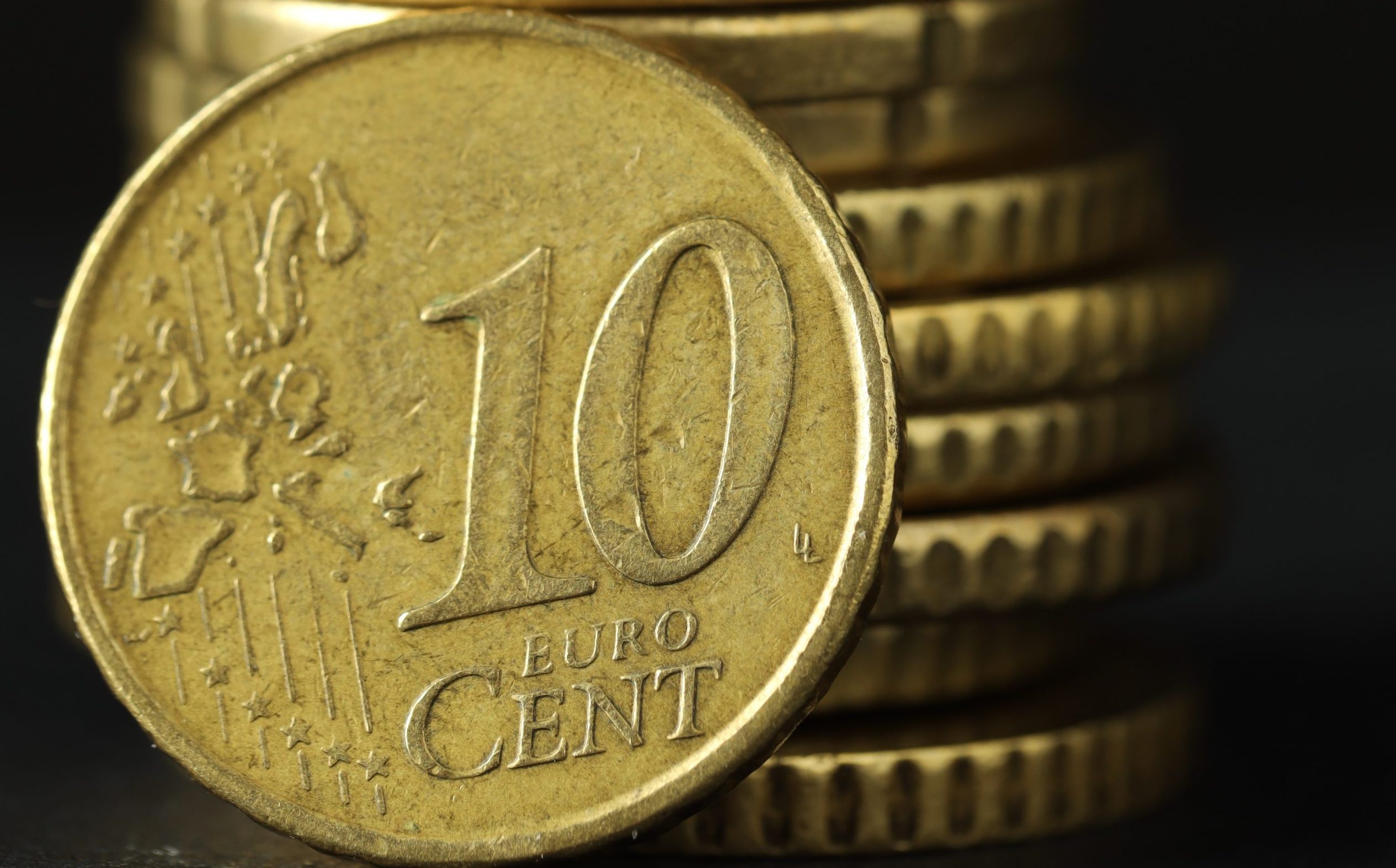 Stacked euro coins on grey table, closeup